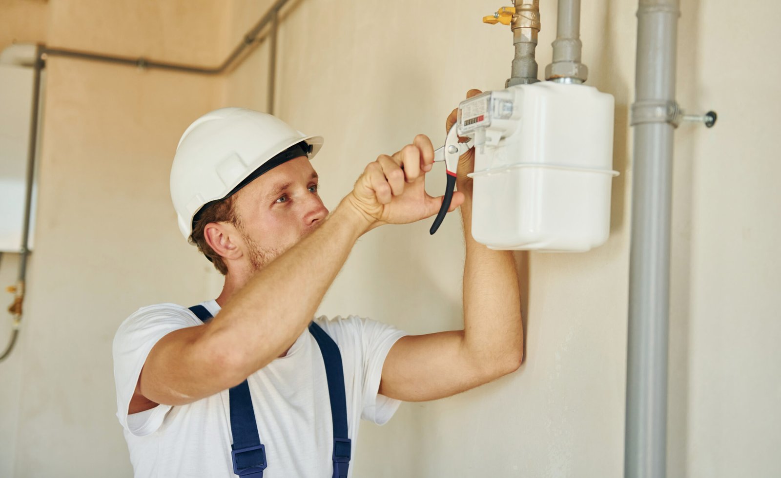 Modern technologies. Young man working in uniform at construction at daytime.